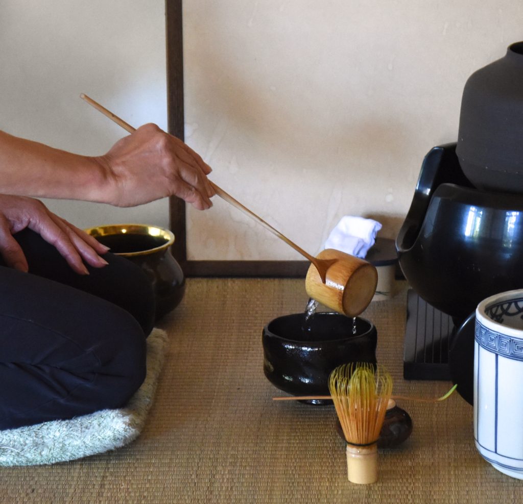 The ladling of water during a Japanese tea ceremony, showing the cultural traditions of Japan. (Image © Meredith Mullins.)