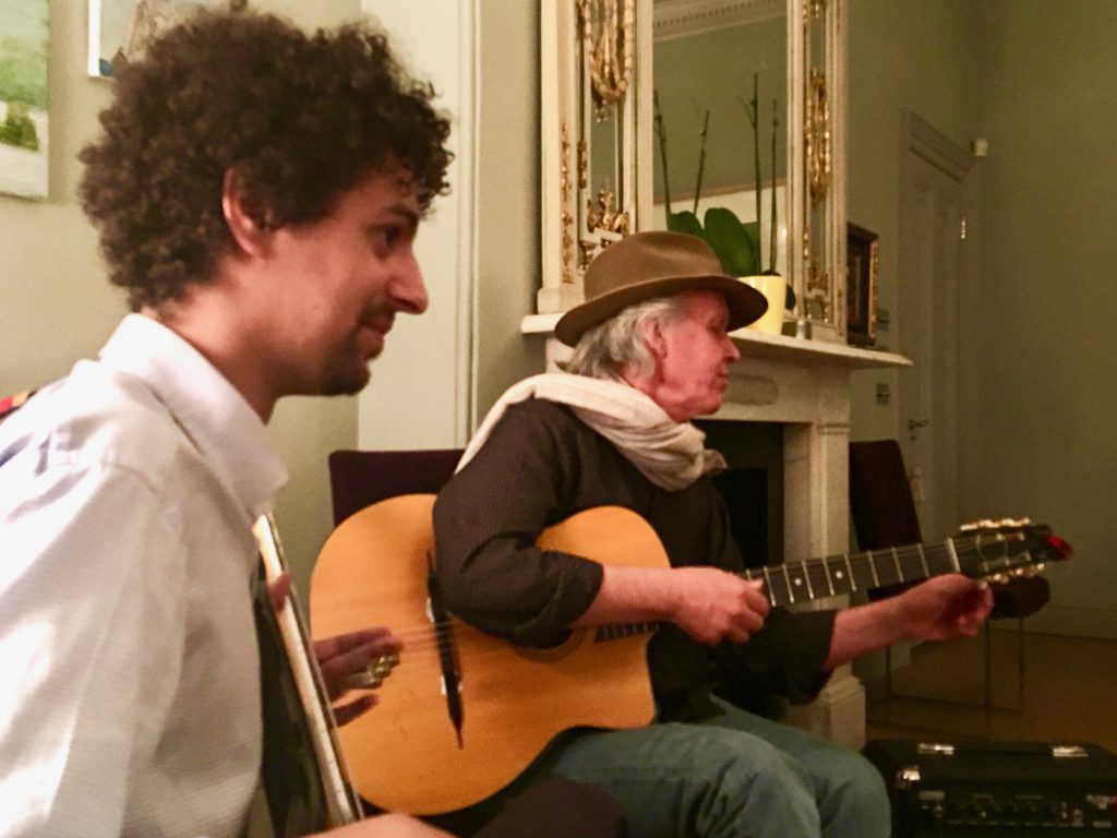 Kiaran O'Donnell and Rick Chelew play guitar at a small gathering, carrying on the Irish tradition of the party piece, sharing songs, stories, and poems. (Image © Joyce McGreevy)