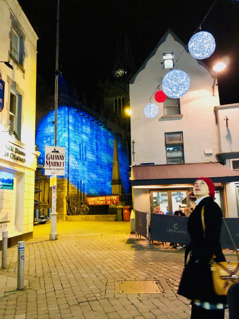 A woman gazing at Christmas decorations in Galway, Ireland embodies the joy of winter wanderlust. (Image @ Joyce McGreevy)
