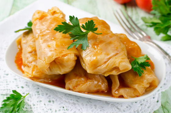 Stuffed cabbage rolls with rice and meat (sarmale), showing cultural traditions of Christmas in Romania and holiday food around the world. (Image © vkuslandia/iStock.)