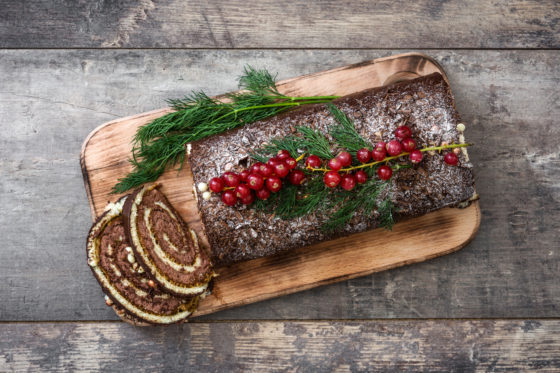 Chocolate yule log cake or Buche de Noel, showing cultural traditions for Christmas and holiday food around the world. (Image © etorres69/iStock.)