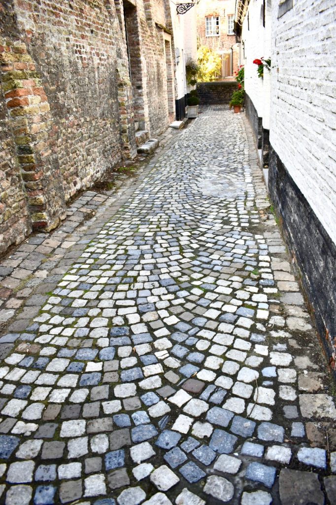 A quiet street in Bruges, Belgium becomes a source of travel inspiration about traveling light. (Image © Joyce McGreevy)