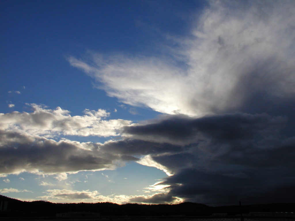 Clouds shaped like a crocodile eating a python, cloud watching while traveling the world. (Image © DMT.)