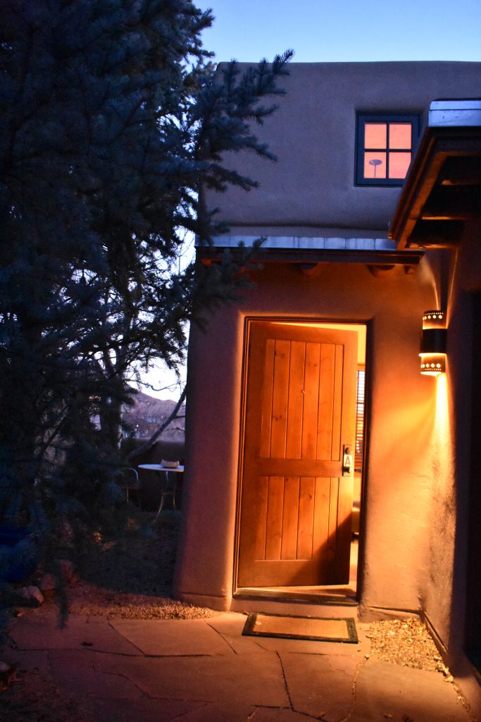 The open door of an adobe shows why Santa Fe, New Mexico inspires wanderlust. (Image © Joyce McGreevy)
