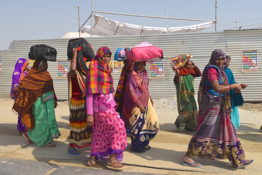 Women traveling to the 2019 Ardh Kumbh Mela in Prayagraj (Allahabad) India, one of the amazing places in the world. (Image © Meredith Mullins.)