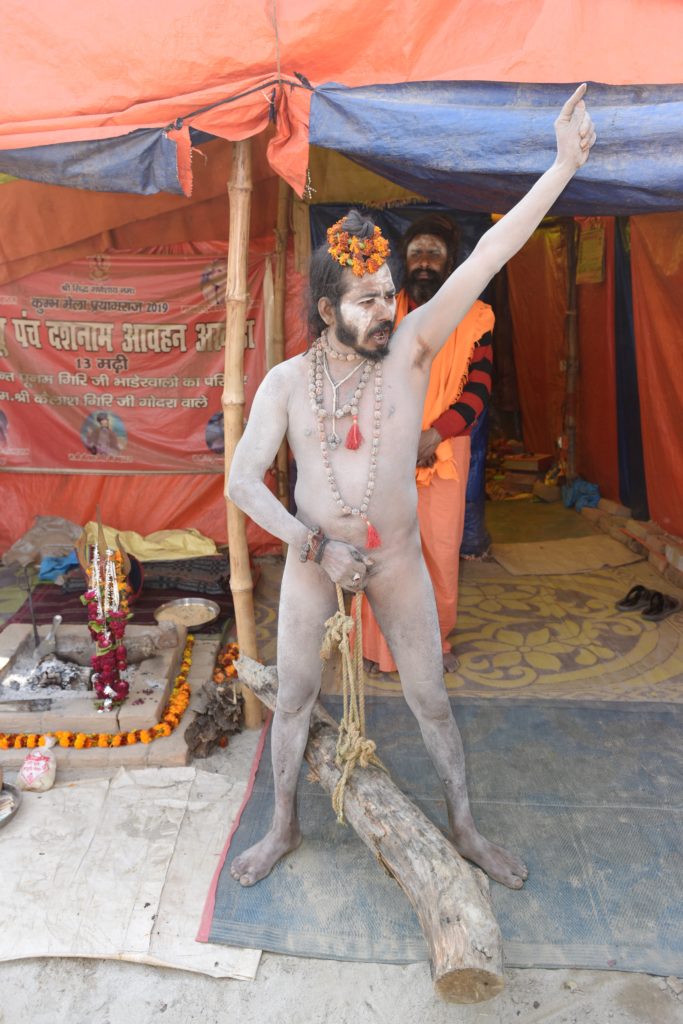 Naga sadhu lifting a log with his penis at the 2019 Ardh Kumbh Mela in Prayagraj (Allahabad), India, one of the amazing places in the world. (Image © Meredith Mullins.)