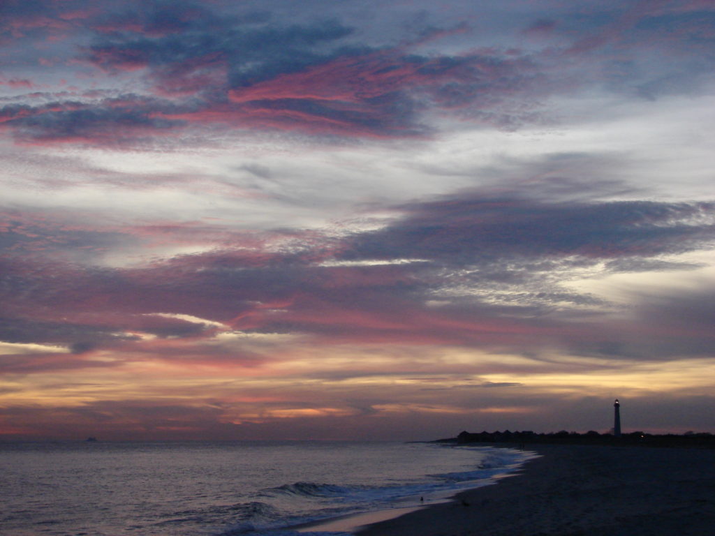 A sunset with lighthouse, cloud watching while traveling the world. (Image © DMT.)