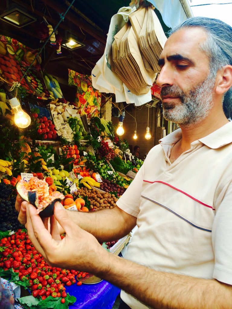 A man selling figs in Kadikoy, Turkey inspires culinary travel tips and other lessons learned from traveling full time. (Image © Joyce McGreevy)