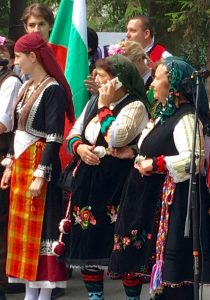 A traditionally dressed Bulgarian woman using a smartphone remind the author that learning a second language means learning a second alphabet, Cyrillic. (Image © Joyce McGreevy)