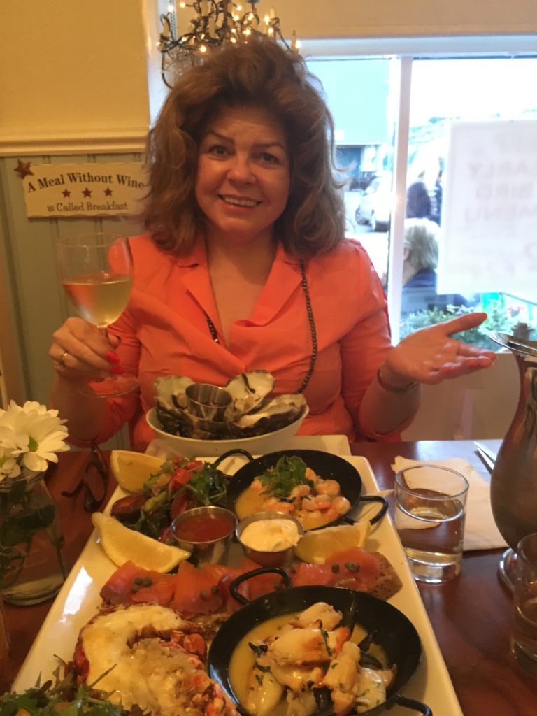 A woman gesturing toward a seafood platter in Howth shows that Ireland’s culinary renaissance has dispelled stereotypes about Irish cuisine. (Image © Joyce McGreevy)