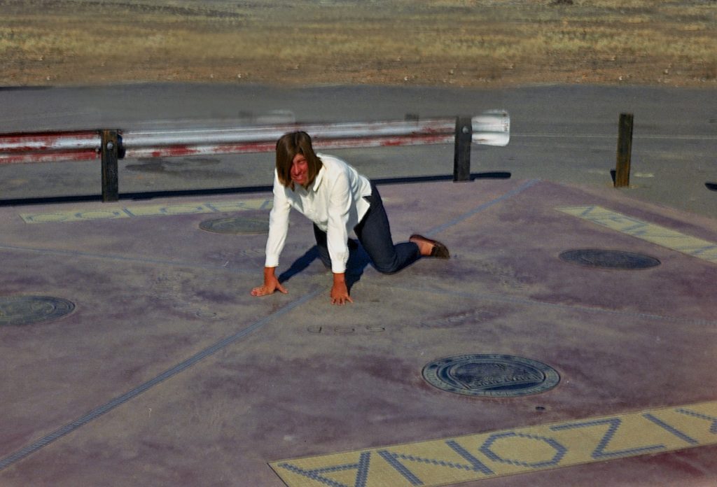 At Four Corners, a roadside sign and roadside attraction in four western states, encouraging the art of travel. (Image © Frank Mullins.)