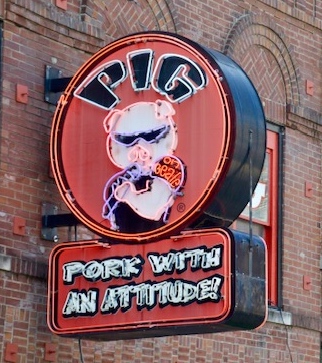 Pork with an attitude roadside sign in Memphis, encouraging the art of travel. (Image © Lauren Gezurian-Amlani.)