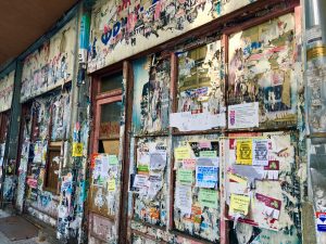 Remnants of posters on a wall in Sofia, Bulgaria exemplify the linguistic landscape global citizens inhabit. (Image © Joyce McGreevy)