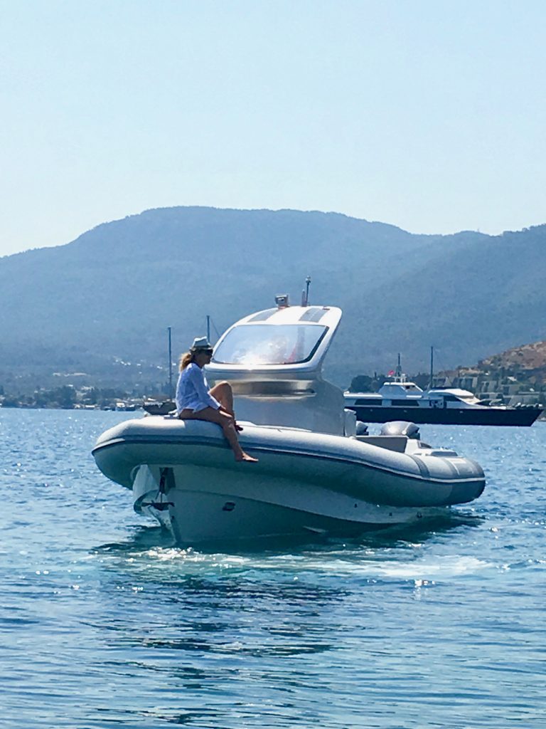 A woman on a boat in Türkbükü, Turkey symbolizes how global citizens navigate culture and language. (Image © Joyce McGreevy)