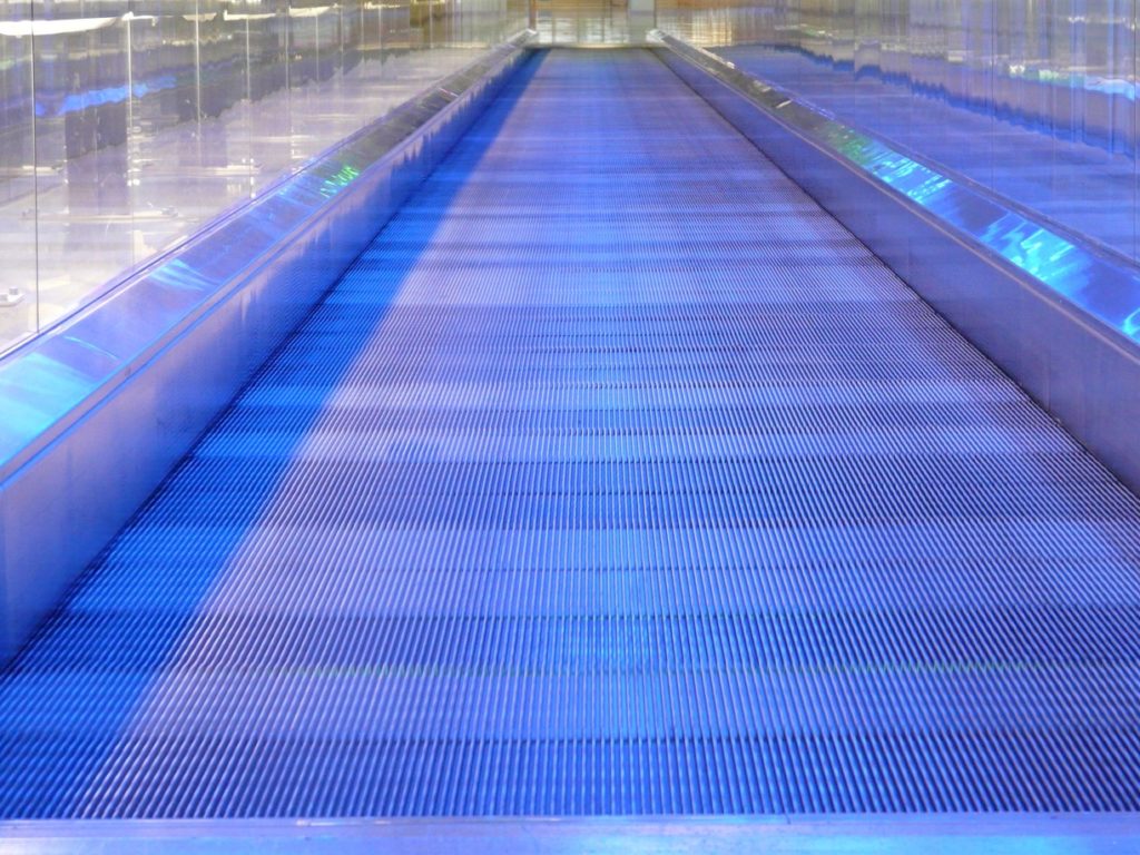 A moving sidewalk at an airport reminds the author of the need for aviation innovations and creative problem solving. [Image public domain]