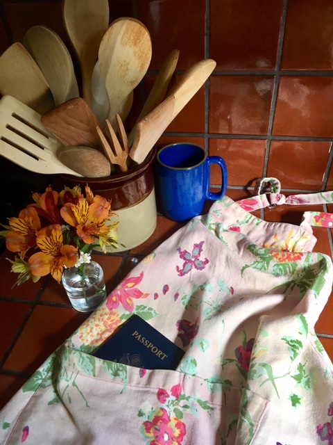 An apron with passport in a kitchen symbolizes the art of travel as a vagabond homebody, not just a digital nomad. (Image © Joyce McGreevy)