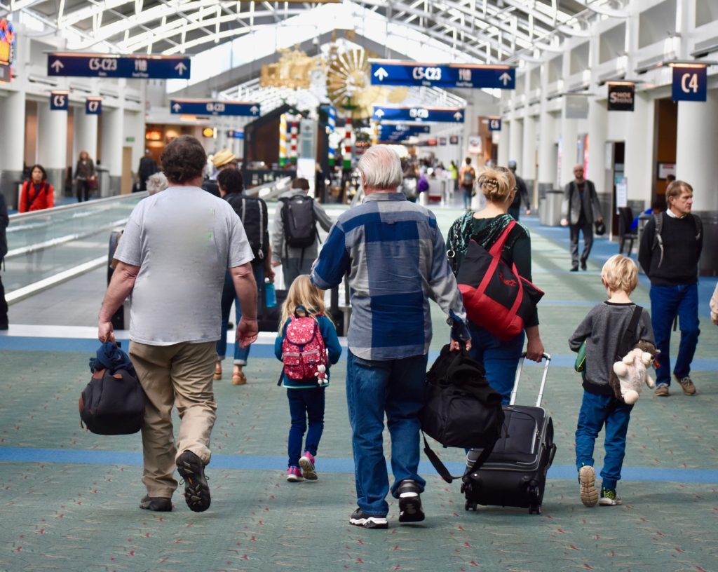 People at an airport evoke the metaphor of carrying where you came from with you as you travel through life. (Image © Joyce McGreevy)