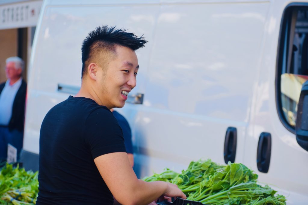 A smiling vendor in Monterey, California reflects the friendliness of farmers markets. (Image © Joyce McGreevy)