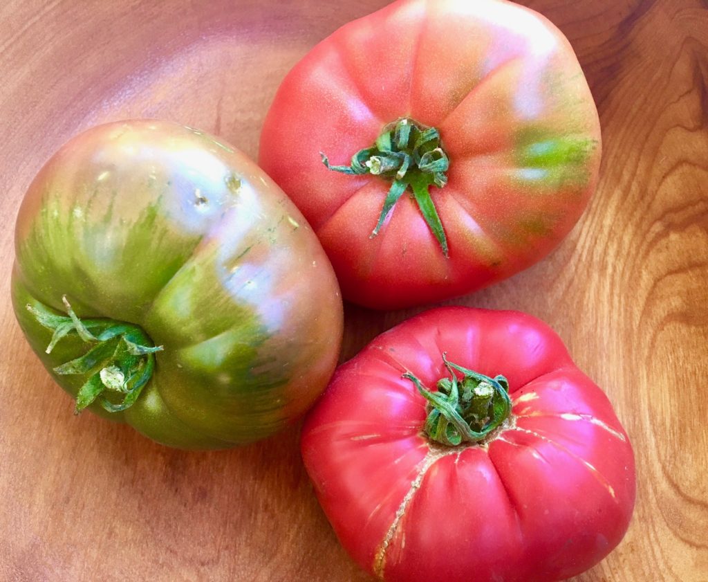 A trio of heirloom tomatoes reflects the appeal of buying organic vegetables at farmers markets. (Image © Joyce McGreevy)