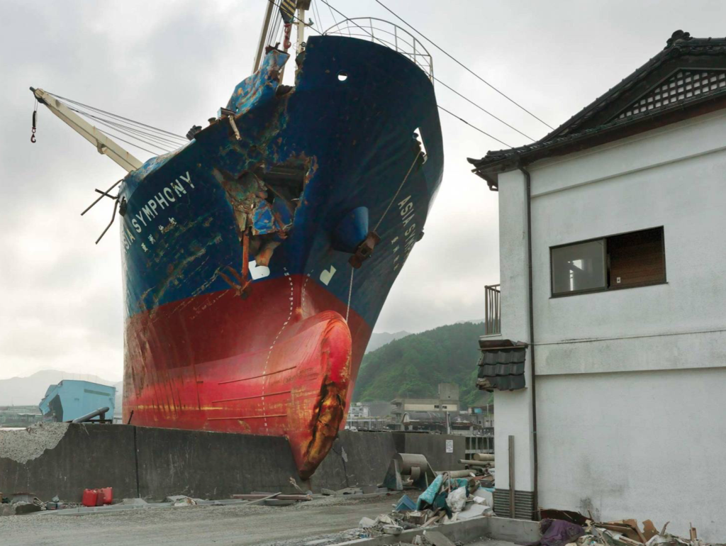 Damaged ship and house after earthquake and tsunami in Tohoku, Japan, part of the Datazone exhibit at the Rencontres d'Arles, using Chancel photographs and crossing cultures to deliver a message via documentary photography. (Image © Philippe Chancel. Courtesy of the artist and the Melanie Rio Fluency Gallery.)