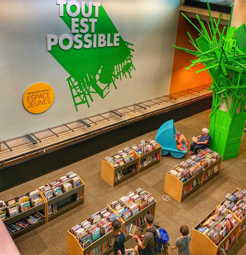 Library patrons at the Grande Bibliothèque, Montréal, Canada, include tourists with wanderlust to travel to public libraries, or library tourism, around the world. (Image © Joyce McGreevy)