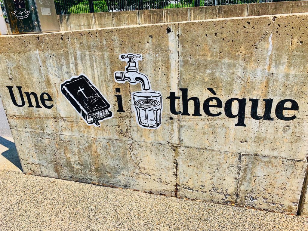 A detail from a rebus mural at the Grande Bibliothèque, Montréal, Canada, shows why wanderlust leads travelers to public libraries around the world. (Image © Joyce McGreevy)