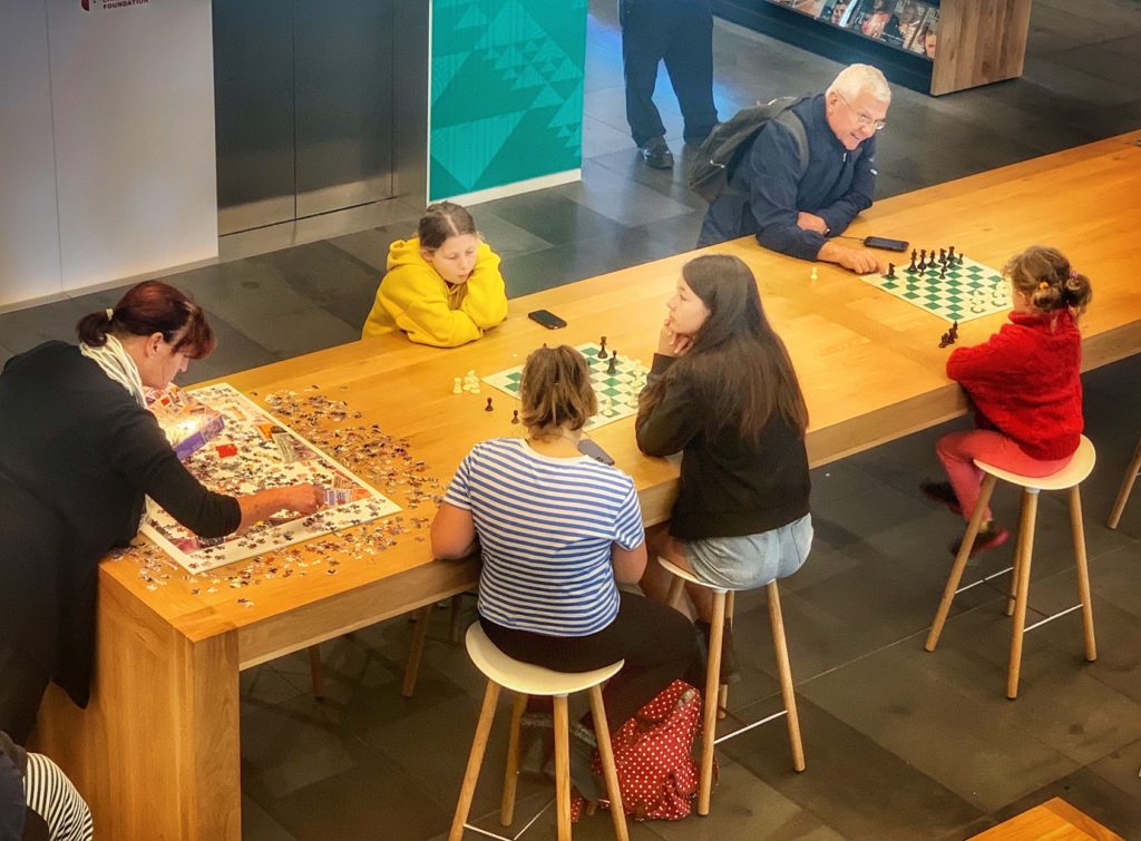 Library patrons playing with board games and puzzles at at the Tauranga Library in Christchurch, New Zealand, reflect the entertaining side of public libraries around the world. (Image © Joyce McGreevy)