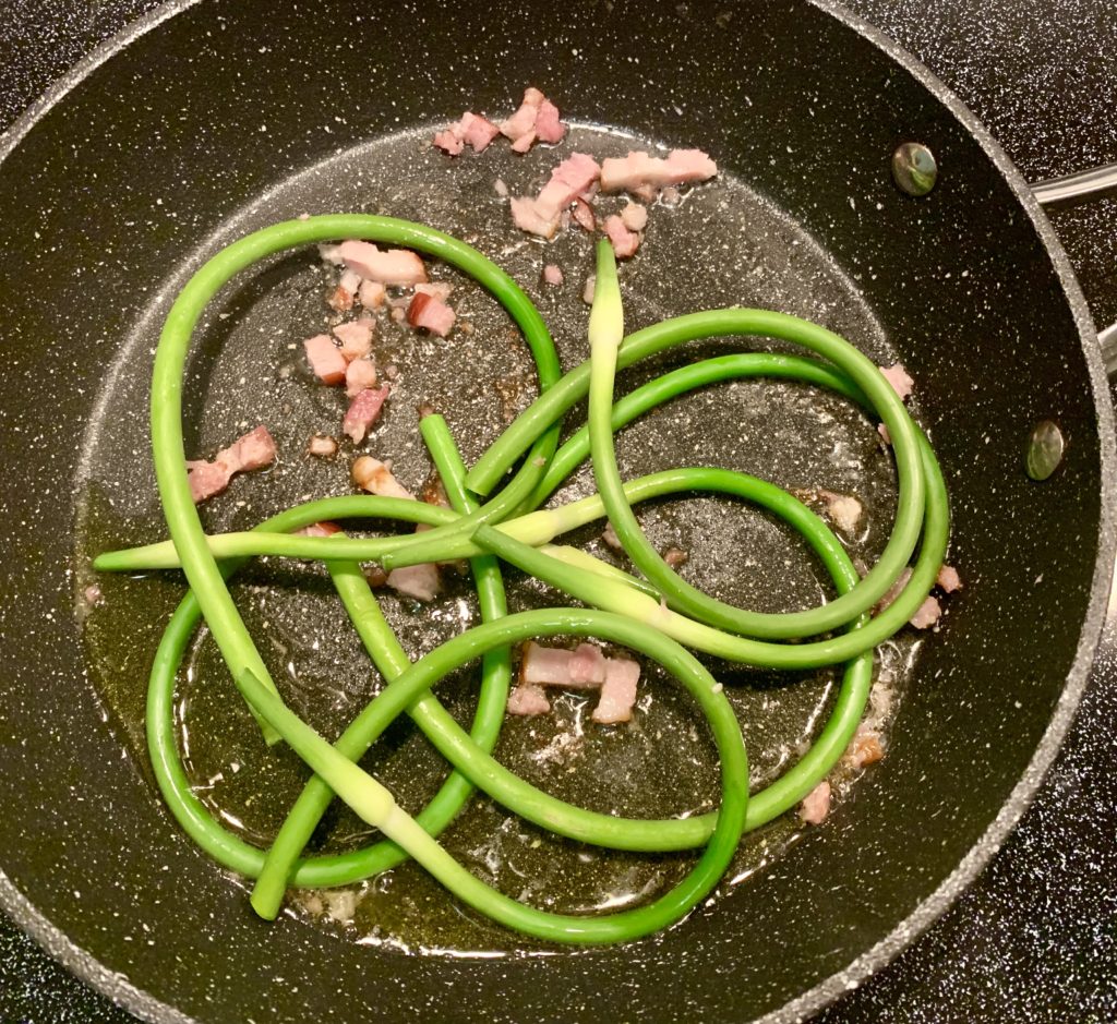 Sautéed ramps in a pan reflect the wide range of the allium family, which includes onions, a staple of global cuisine across cultures. (Image © Joyce McGreevy)