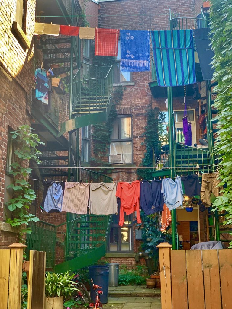 Colorful laundry in a ruelle verte, or green alley, in Montréal, Canada reflects creative problem-solving that makes everyday life better. (Image © Joyce McGreevy)