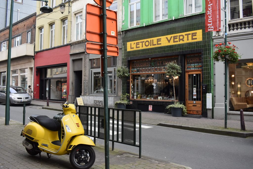 A street scene in Brussels, with yellow motorbike and "L'Etoile Verte" sign, inspires ideas for comic-book art, a cultural tradition in Belgium. (Image © Joyce McGreevy)