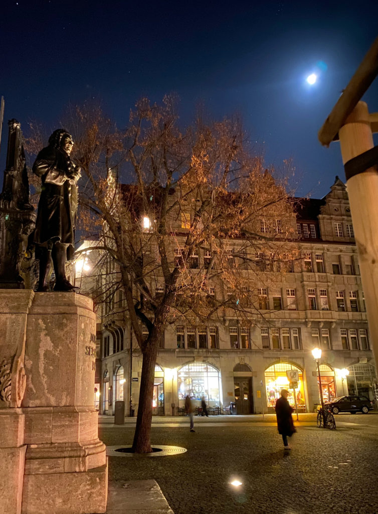 A statue of Johann Sebastian Bach in the moonlight outside Thomaskirche in Leipzig inspires wanderlust to explore more of Germany’s holiday traditions, including Bach’s Christmas cantatas. (Image © Joyce McGreevy)