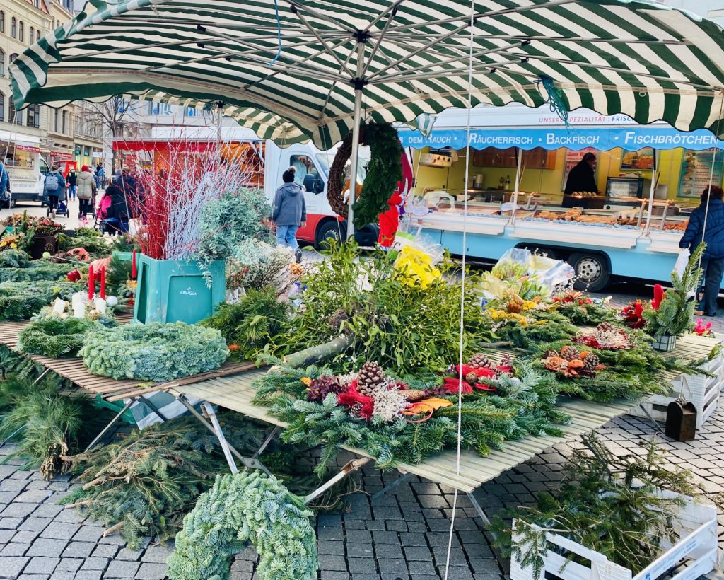 A vendor’s stall selling pine wreaths and boughs at the Leipziger Weihnachtsmarkt, the annual Christmas market in Leipzig, reflects one of Germany’s Christmas traditions. (Image © Joyce McGreevy)