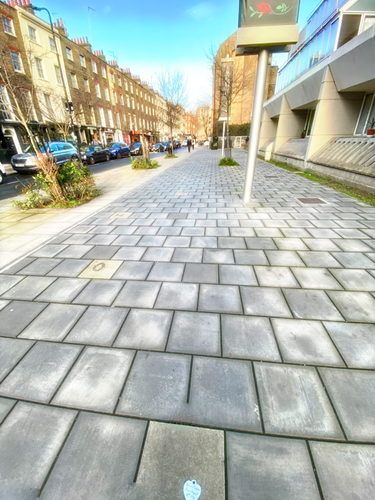 On Marchmont Street, London a token embedded into the pavement becomes an historical marker for those with the focus to spot it. (Image © Joyce McGreevy)