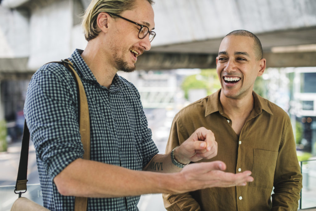 Two men enjoying conversation evoke the fun of learning a second language. (Public domain image by Pxhere)