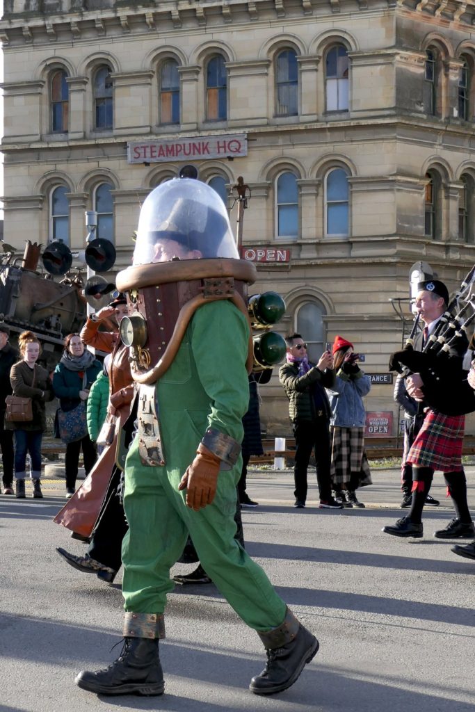 A steampunk spaceman, bagpiper, and crowds enjoy Steampunk Festival NZ, which celebrates the Victorian cultural heritage and creative thinking of Oamaru, New Zealand. (Image © Liz Cadogan)