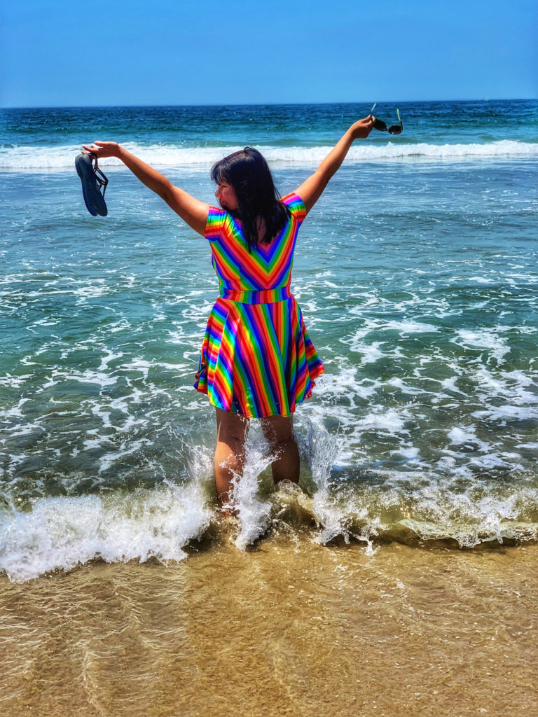 A woman exuberantly enjoying the beach reminds the author of the transportive power of travel memories inspired by music. (Image © by Joyce McGreevy)