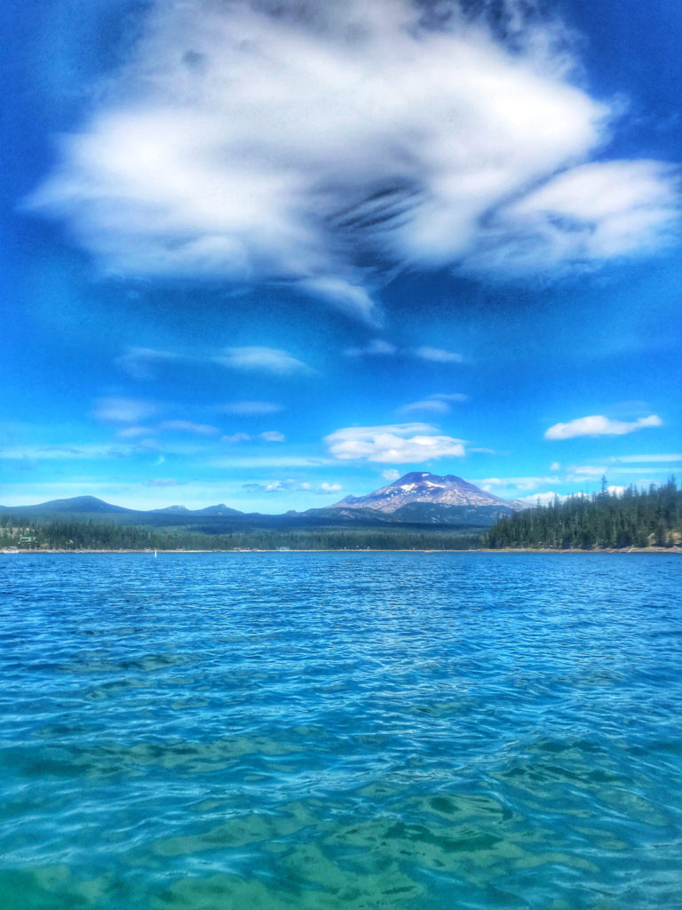 A blue lake under a blue sky, Elk Lake, Oregon, inspires the author to reflect on personal and cultural beliefs about water, including the blue mind and blue spaces theory. (Image © Rayna Bevando)