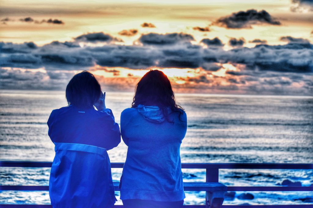 Two women looking out to sea remind the author that blue spaces can inspire reflection, personal and cultural beliefs about water, and the cultivation of a blue mind. (Image © Joyce McGreevy)