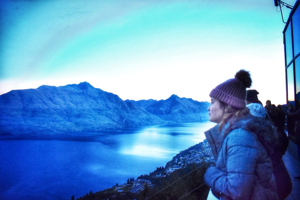 A woman gazing out over lake reminds the author that blue spaces inspire reflection, personal and cultural beliefs about water, and the cultivation of a blue mind. (Image © Joyce McGreevy)