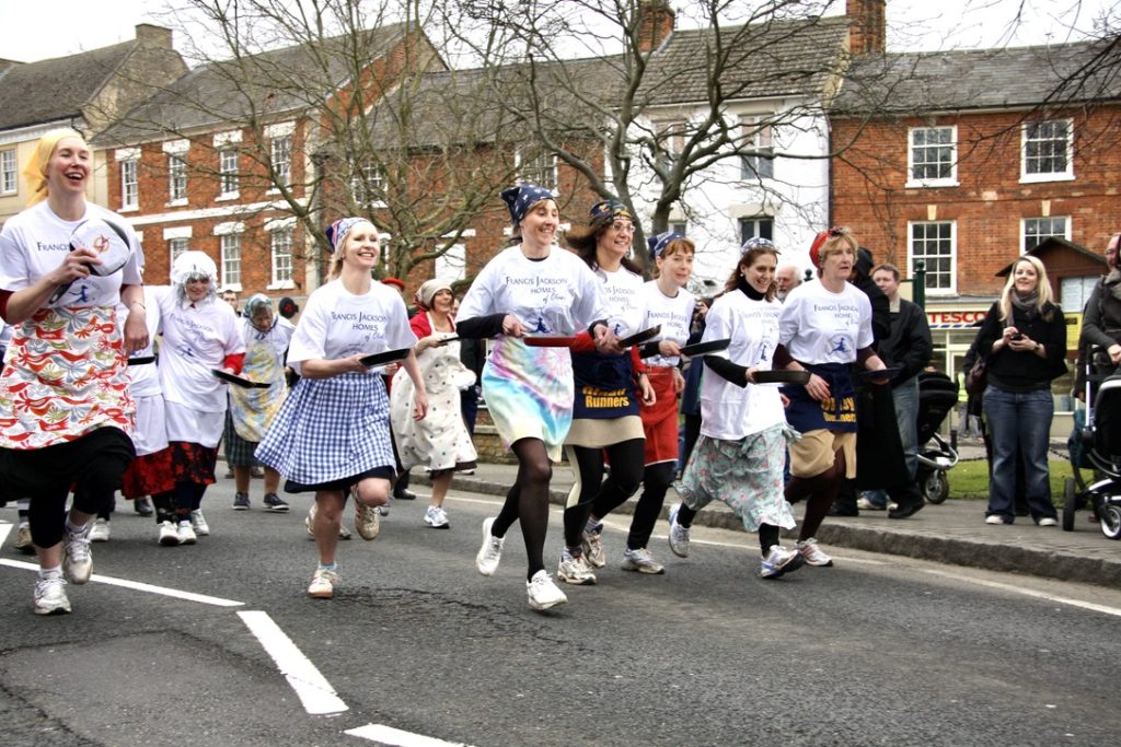 Women running with frying pans in the Pancake Race in Olney, England evoke the fun and history of easy pancakes around the world, (Image by RobinMeyesrcough, licensed by Wikemedia Commons CC BY 2.0)