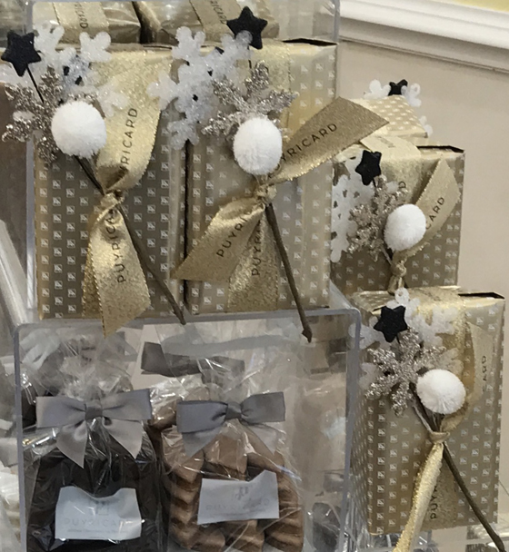 Chocolate and holiday boxes in a store window, showing the cultural traditions of chocolate on National Chocolate-Covered Anything Day. (Image © Meredith Mullins.)