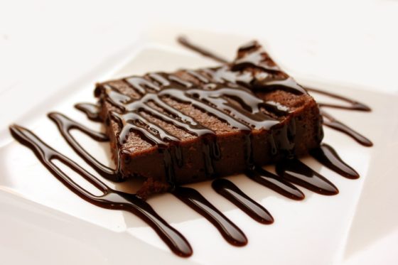Brownie covered in chocolate sauce, showing cultural traditions of National Chocolate-Covered Anything Day. (Image by PxHere.)