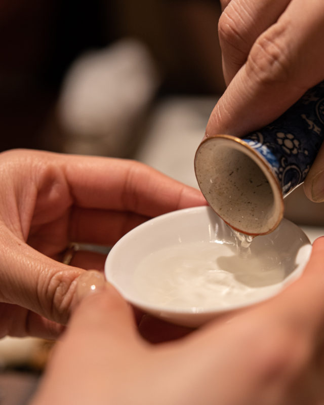 Sake is poured into a ceramic cup in Tokyo, the setting for Yuma Wada’s online Japanese food tour and trivia night. (Image © by Yuma Wada/ Ninja Food Tours)