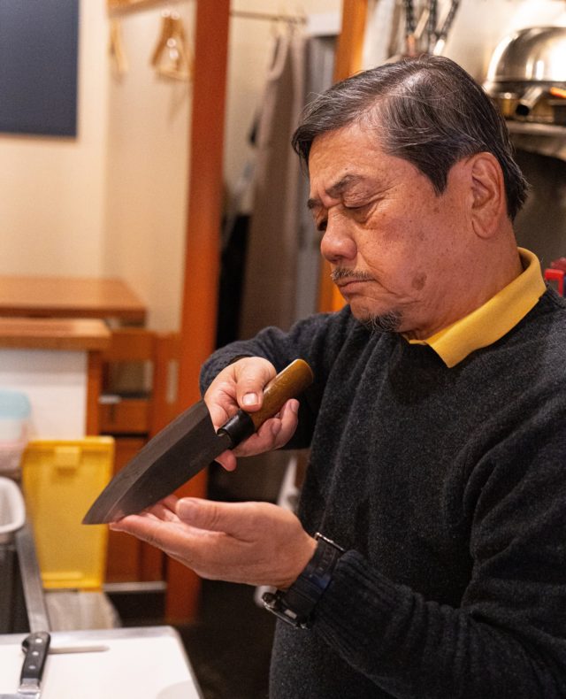 Ninja Food Tours tour guide Kaz displays a chef’s deba knife in Tokyo, the setting for Yuma Wada’s online Japanese food tour and trivia night. (Image © by Yuma Wada/ Ninja Food Tours)