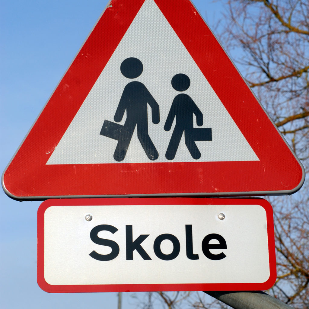 From Denmark, this triangular school zone sign with a thick red border and stylistically simple figures with no hands, feet, or clothing, shows a girl and a boy on their way to school and is part of a series of school zone signs from different cultures. Image © Carsten Medom Madsen/iStock .
