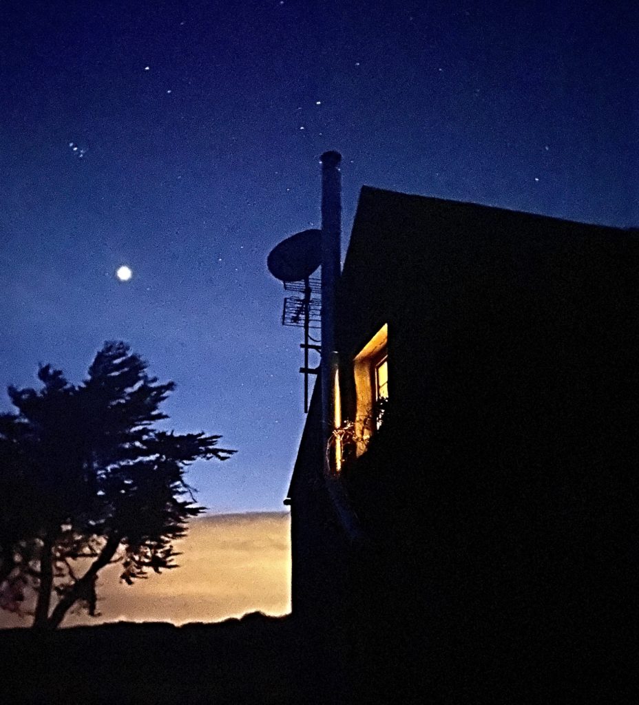 Starlight above an Irish cottage with a satellite dish evokes the way nature and technology support virtual travel, allowing virtual visitors to stay connected across the miles during a time of social distancing and self-isolation. (Image © by Joyce McGreevy)