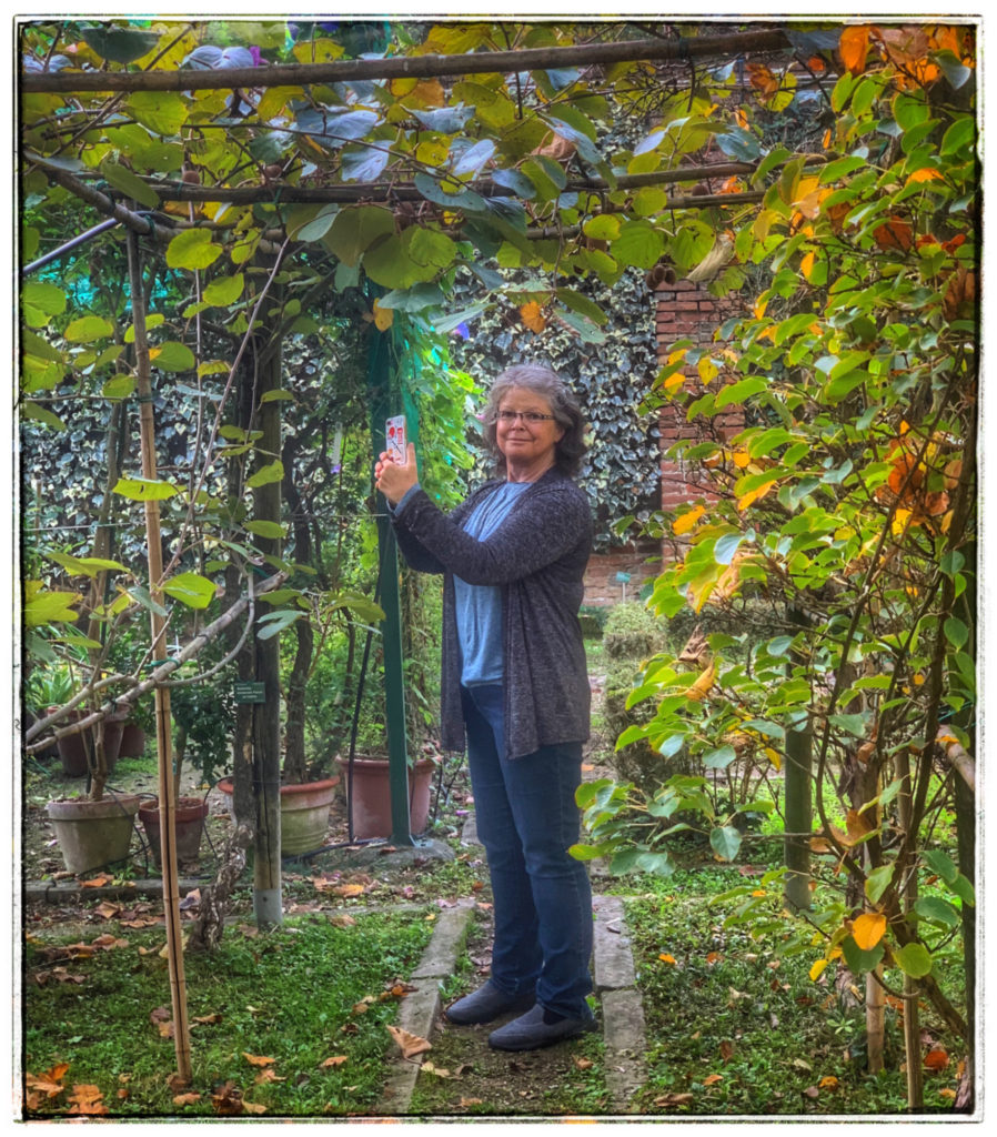 A visitor photographing one of the many gardens in Italy recommended for a visit in the author's travel planning tips for Italy. (Image © by Joyce McGreevy)